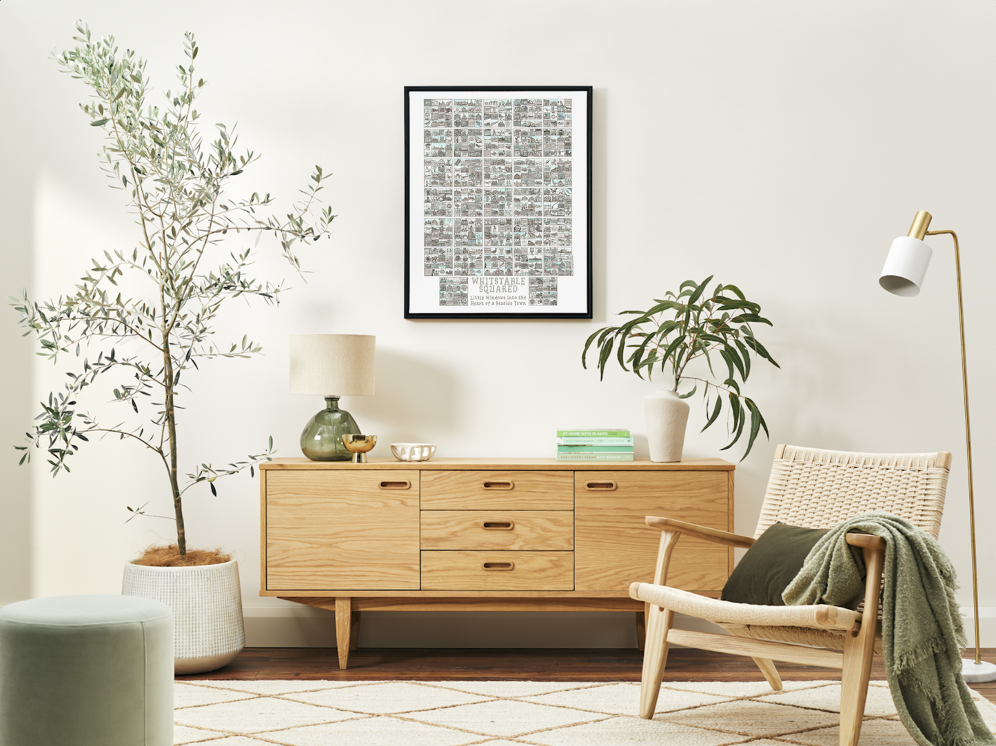 Black framed A2 poster sized Whitstable Squared  print on living room wall with modern furniture and plants
