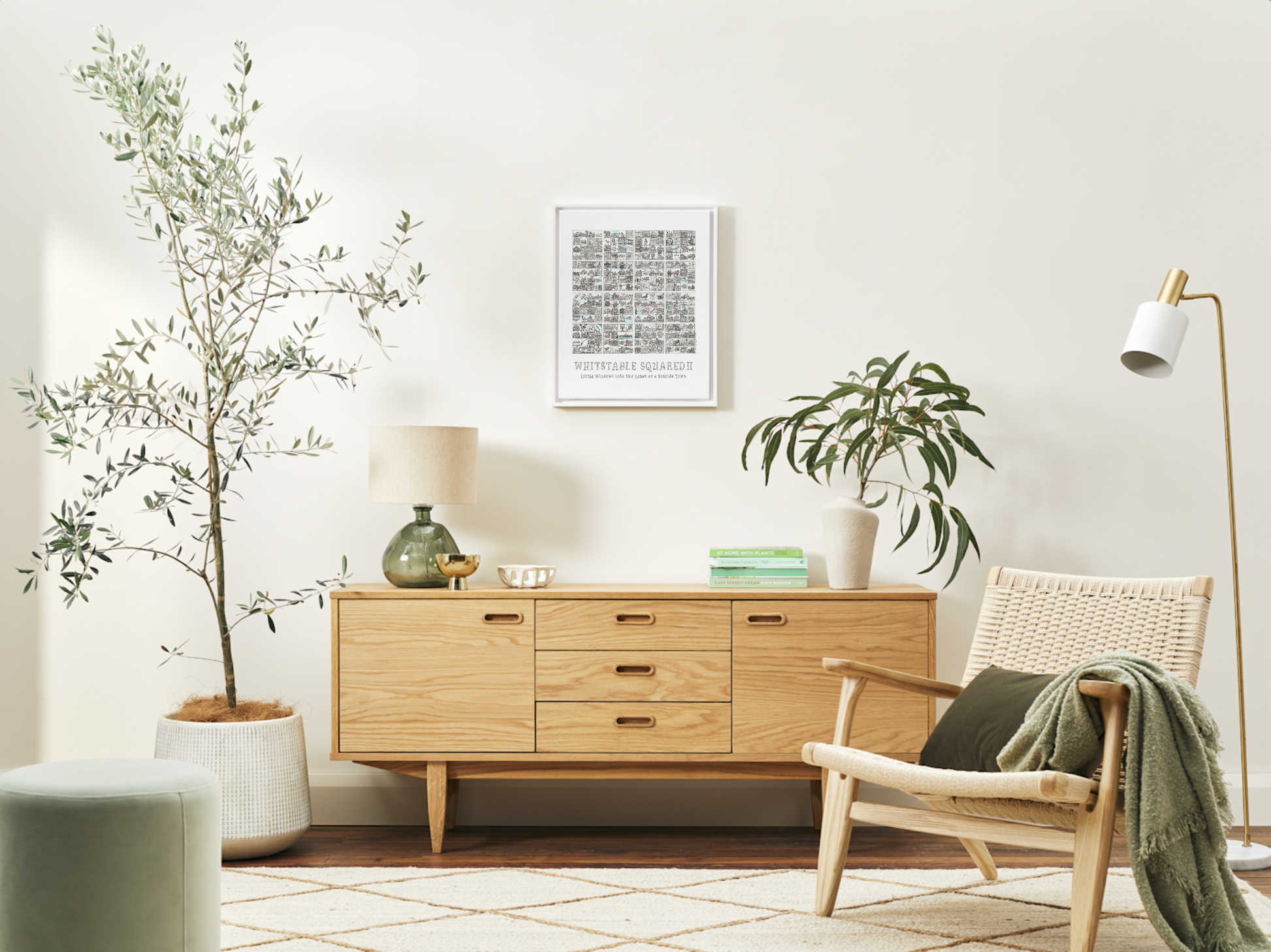 'Whitstable Squared II' A3 print with white frame on a white wall in a modern living room with wooden sideboard, chair, and decorative plants.